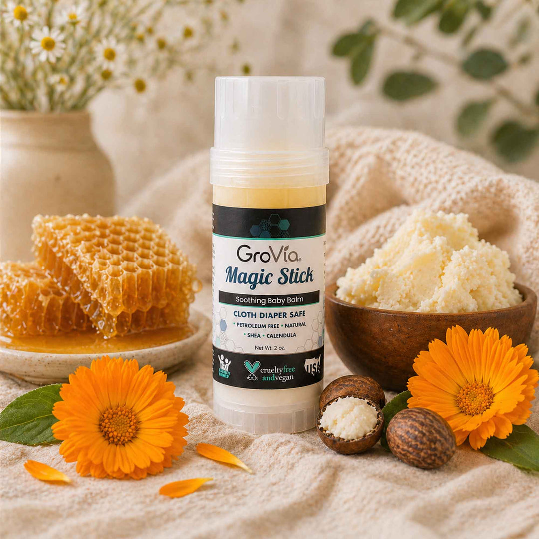 GroVia Magic Stick with natural elements like flowers and honeycomb on a soft fabric background