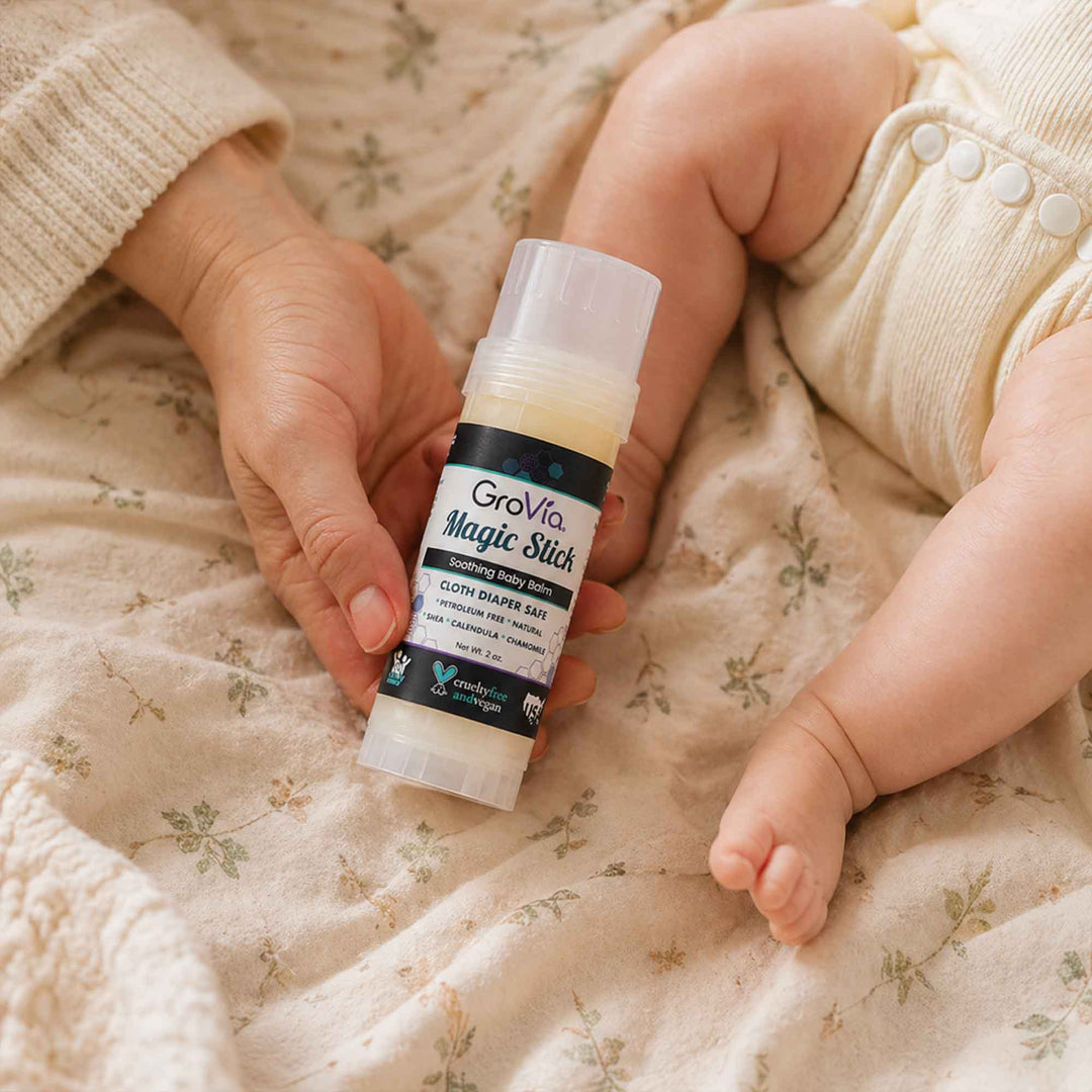 Person holding a Grovia Magic Stick next to a baby&